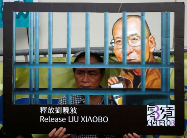 香港市民支援爱国民主运动联合会10日在北京驻香港联络办公室大楼外发起接力静坐，要求北京当局释放刘晓波出国治病。（路透）