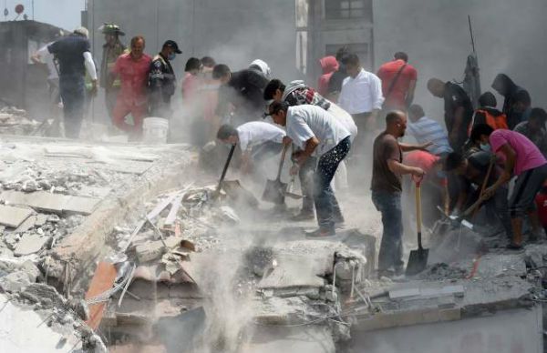 强震过后，墨西哥市民从废墟中救出一名伤者。(美联社)