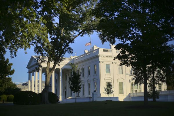 川普总统夫妇及潘斯副总统夫妇2日在白宫草坪前，低头哀悼在拉斯维加斯遇害的无辜罹难者。(美联社)