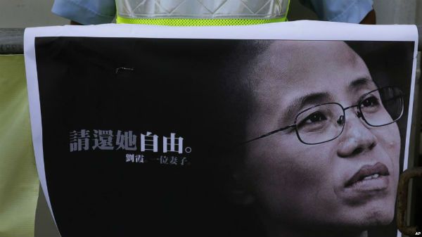 一名抗议者手举诺贝尔和平奖得主刘晓波的遗孀刘霞的照片在北京驻香港中联办外举行示威，要求立即释放被软禁的刘霞。（2017年7月13日）