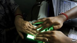 在加尔各答一名印度妇女在工作人员的帮助下扫描她的指纹。 （资料照片）