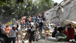 人们在墨西哥城建筑物倒塌造成的瓦砾中搜救（2017年9月19日）