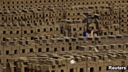 印度窑工在印度窑中搬运砖块(资料照片)