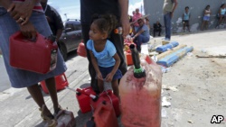 在波多黎各的圣胡安市，一个3岁小孩和家人一起在加油站外面排队（2017年9月25日）