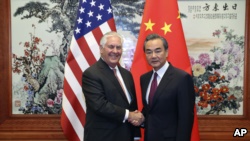 美国国务卿蒂勒森（左）与中国外交部长王毅（右）在人民大会堂会面前握手。（2017年9月30日）