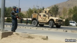一名阿富汗警察在喀布尔的自杀式汽车炸弹袭击现场警戒。（2017年9月24日）