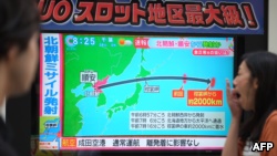 日本東京行人經過正在播放朝鮮試射導彈新聞的電子屏幕（2017年9月15日）。