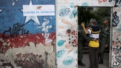 委内瑞拉周日举行地方选举，一名男子在首都加拉加斯的投票站前被警卫搜身。（2017年10月15日）