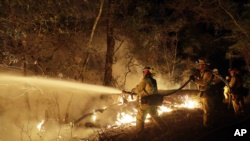 在美国加州桑塔罗萨郡，消防队员同野火奋战（2017年10月14日）