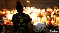 一名女子在拉斯维加斯在枪击事件地点为死难者烛光守夜。（2017年10月2日）
