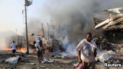 索马里老百姓走过首都摩加迪沙的爆炸现场。（2017年10月14日）